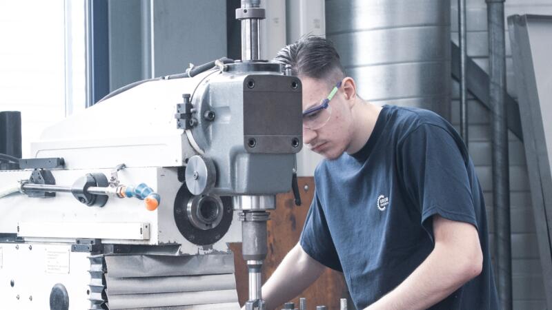 Auszubildender Polymechaniker an Maschine bei GROB AG